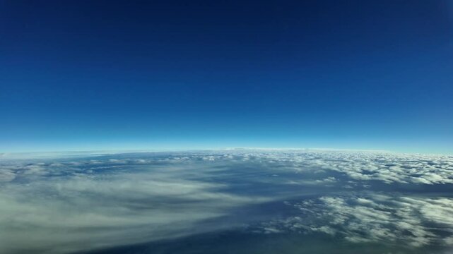 Pilot POV flying at stratosphere level and supersonic speed. Aerial footage taken from fighter cockpit jet flying very high at sunset over layers of stratus clouds. 4K. Hyper lapse.