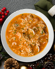 Rice soup with shrimp and clams. Top view table with Christmas decoration.