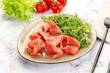 Sliced salmon with fresh arugula