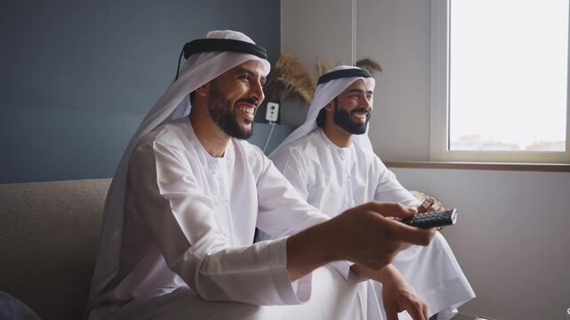 Cinematic video of two friends spending time together in a modern apartment in the united arab emirates. Emirates people with the traditional white kandura in Dubai.