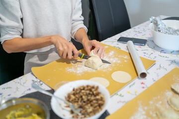 Woman making homemade food on the kitchen room - varenyky, pierogi with mushrooms. Ukraine cuisine, natural homemade food