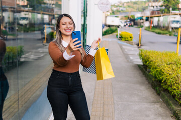 Woman shopping talking on her cell phone during black friday discounts. Happy customer.