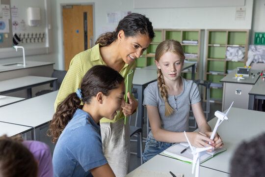 Students showing their renewable energy project to their teacher - Powered by Adobe