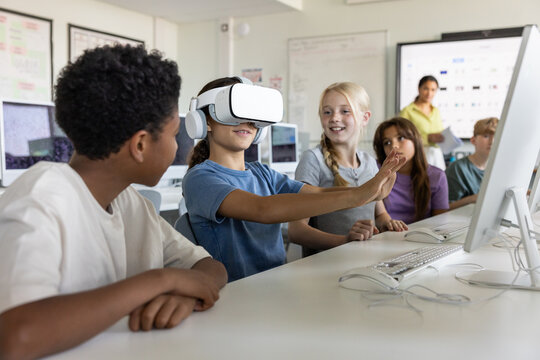 Girl pupil using a VR headset in computer science class