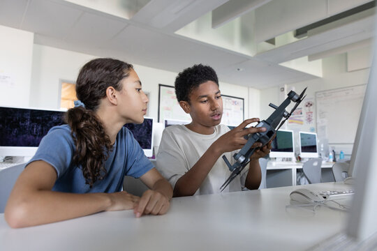 School students looking at a drone in computer science class