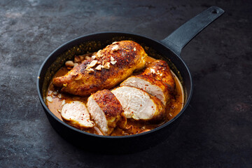 Roasted spicy butter chicken breast fillet in red curry gravy sauce with coconut, lime, and cashew...