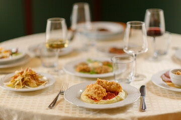 Close up on italian traditional northern food on a restaurant table. Many dishes are visible.