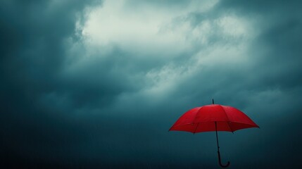 A solitary red umbrella struggling against the force of a powerful storm set against a turbulent gray sky