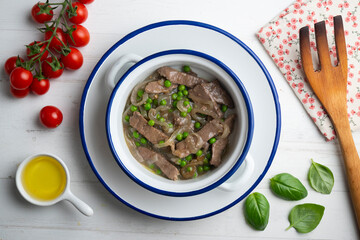 Strips of beef cooked with onion and peas. Top view table with  decoration.