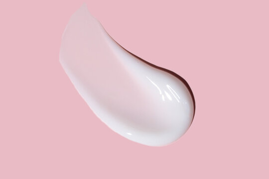 Close-up of creamy foundation texture on a pink background