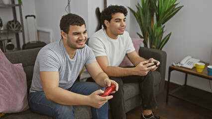 Two men gaming together on a couch in a cozy living room, displaying friendship and leisure.