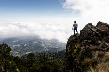 Hiker overlooking valley from mountain peak