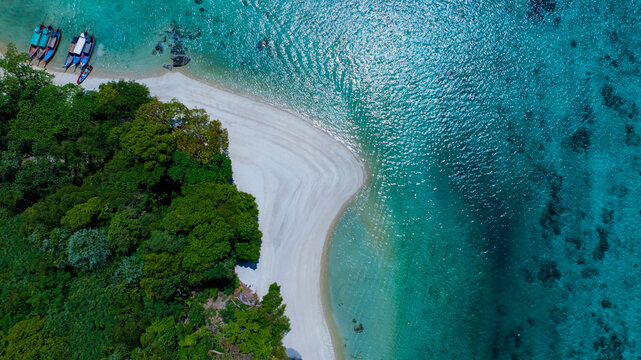 The aerial view of white sand beach tropical with seashore as the island in a coral reef ,blue and turquoise sea Amazing nature landscape with blue lagoon