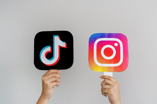 Girls Teen Hands Hold  TikTok and  Instagram logos on Gray background. Concept of Teenagers Using the Most Popular Social Networks. Turkey, Istanbul, September 17, 2024.
