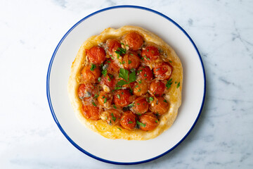 Savory tarte tatin with cherry tomatoes. Top view table with  decoration.