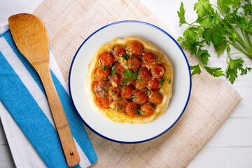 Savory tarte tatin with cherry tomatoes. Top view table with  decoration.