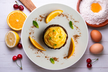 Chocolate tartlets with orange cream. Top view table with  decoration.