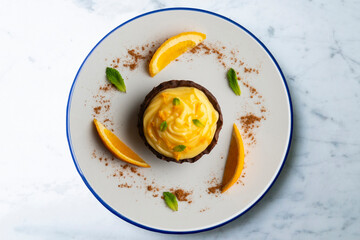 Chocolate tartlets with orange cream. Top view table with  decoration.