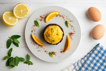 Chocolate tartlets with orange cream. Top view table with  decoration.