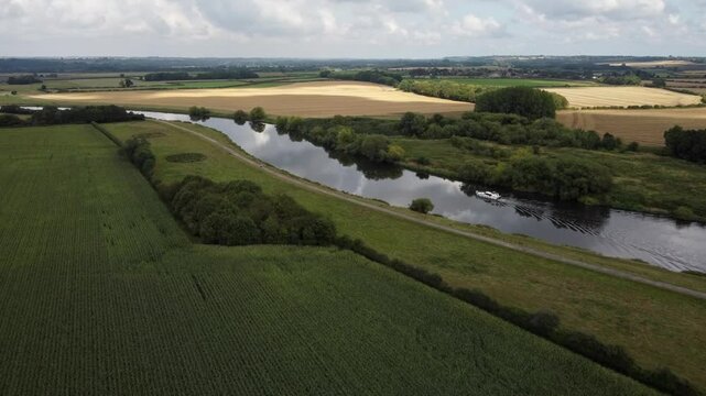 The Nottinghamshire Countryside Drone footage crosses the River Trent as a River Boat sails along on a Sunny, Summers day.