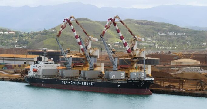 Noumea New Caledonia. Cranes unload nickel ore off cargo ship.