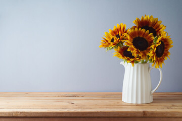 Autumn background with sunflowers in vase on wooden table