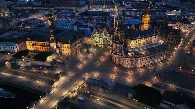Dresden, Saxony, Germany, aerial video footage during night, hovering near Augustus Bridge and Castle Square with Cathedral of the Holy Trinity, streets and squares illuminated 