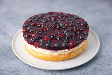 Tyrolean pie with soft custard, cherries and blueberries. Biscuit pie with light cream, with fresh berries and jelly. Traditional baking. Close-up, selective focus.