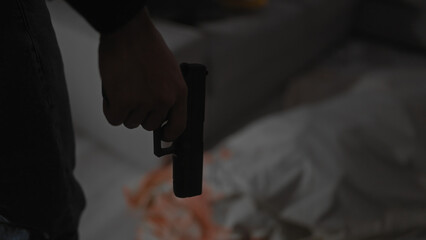 African american man indoors holding a gun with a blurred background suggestive of a tense situation.