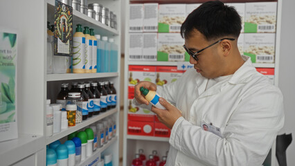 A young chinese man inspects a medicine bottle in an indoor pharmacy, surrounded by various...