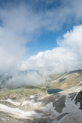 Snowy mountains and blue sky in the background. Snowy mountains with magnificent white clouds. Uludağ hiking routes. Clouds over Bursa Uludağ mountains. Blue sky, snowy and cloudy hills.
