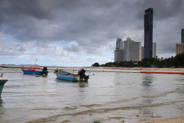 fishing boats in the sea against the background of high-rise modern buildings