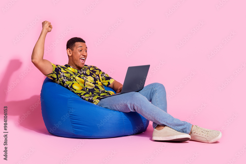 Canvas Prints Full length photo of handsome young guy sit bean bag netbook win dressed stylish tropical print garment isolated on pink color background