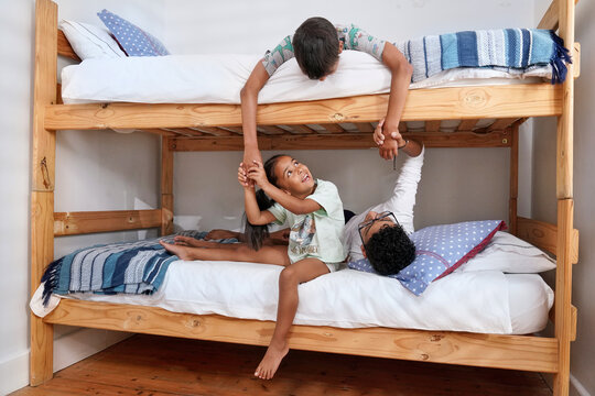 Siblings playing on bed