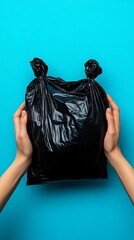 Hands Holding a Black Plastic Bag on Blue Background