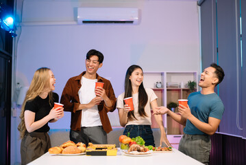 Young Asian Friends Celebrating with Laughter and Food at a Modern Evening Party