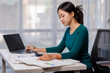 Accountant working on desk using laptop documents calculator to calculate financial report in office business accounting finance concept
