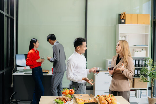 Young Asian Professionals Celebrating with Pizza and Drinks in a Modern Office Setting