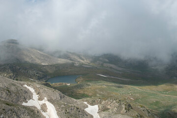 Uludağ glacial lakes. Snowy lake view in cloudy and sunny weather. Lake view in snowy foggy weather. Mountain view covered with blue clouds and snow. Uludağ peak. Bursa, Türkiye.
