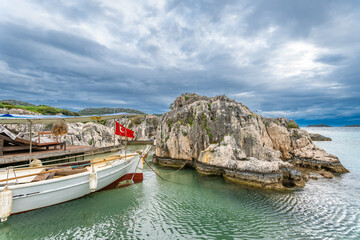 Boat with Turkish flag against rock  drama sky Simena  ancient city