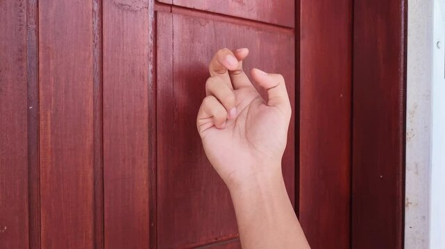 Knocking on the wooden door of the house	