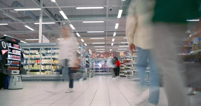 Diverse Male and Female Shoppers, Including Families and Individuals with Shopping Carts and Baskets, Navigate Supermarket Aisles. People Shopping for Groceries. Establishing Timelapse Footage