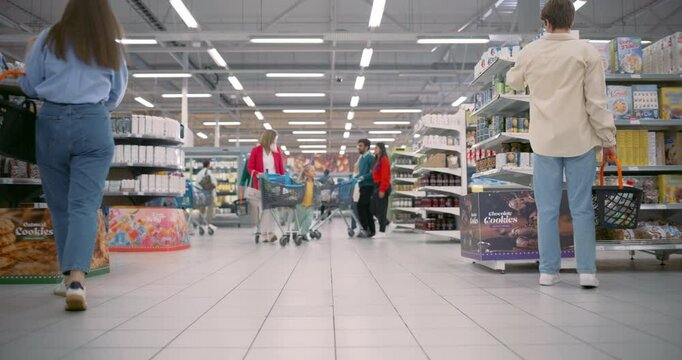 Lively Supermarket Scene with Shoppers of Different Ages and Ethnicities. Families, Couples, and Individuals Pick Up Groceries, Comparing Prices and Grabbing Deals on Packaged Items