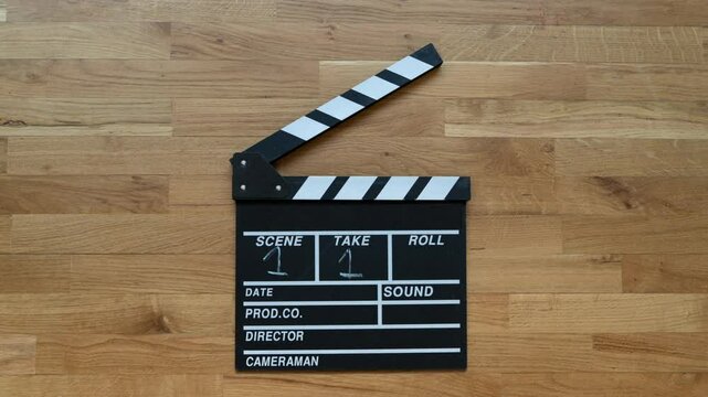 A stop-motion animation of a classic  black and white clapperboard with white chalk numbers 
