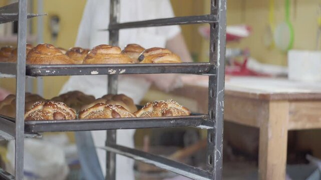 Delicious freshly baked croissant at a bakery kitchen with chef preparing dough, closeup
