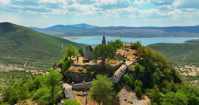 Drone orbiting the Crkva Na Valu Vracenovici church, sunny day in Montenegro