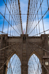 Detalles arquitectónicos del famoso puente de Brooklyn en New York, USA. Cableado y arcos de piedra vistos desde abajo, desde el paso peatonal, en uno de sus dos pilares, el más cercano a Manhattan.