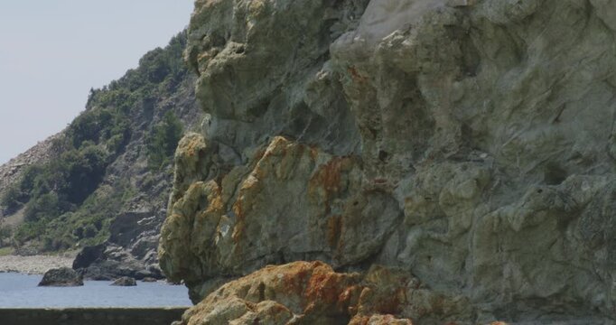 Rugged Cliffs With The Giant Statue At The North Side Of Monterosso al Mare, Liguria, Northern Italy. Panning Up Shot