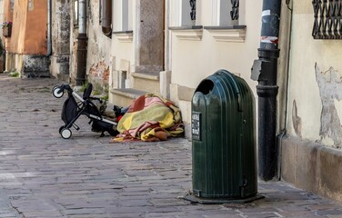 A person hidden under blankets sleeping on the street.