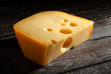 cheese chunk on black wood background